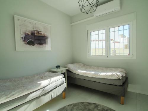 ein Zimmer mit zwei Betten und einem Fenster in der Unterkunft Villa Fresa in Fuengirola