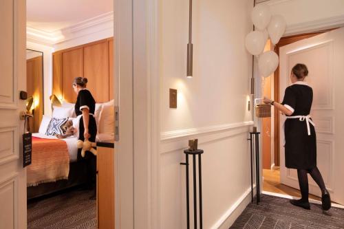 two women are standing in a hotel room at Hôtel Vernet Champs Elysées Paris in Paris