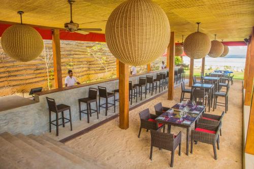 a restaurant with tables and chairs and a person in the background at W15 Weligama in Weligama