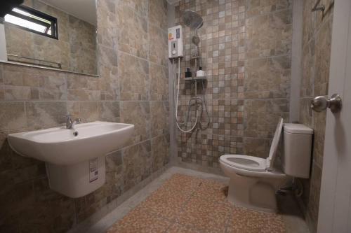 a bathroom with a sink and a toilet at Hugs Home & Cafe Trang in Trang