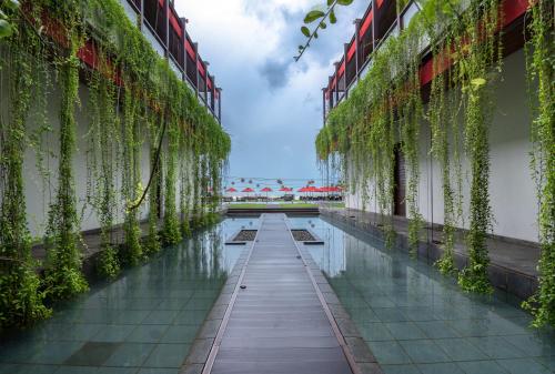 a corridor of a building with water and plants at W15 in Weligama