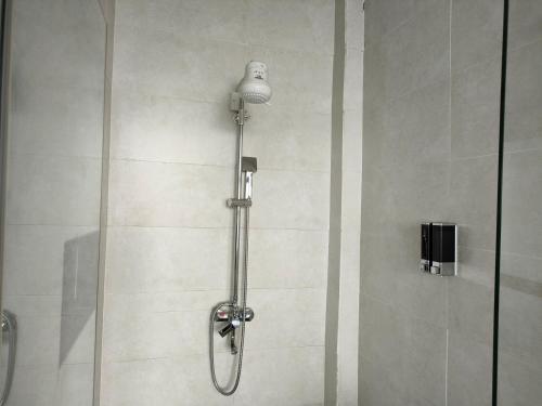 een douche met een douchekop in de badkamer bij THE HOTEL EZRI in Meru