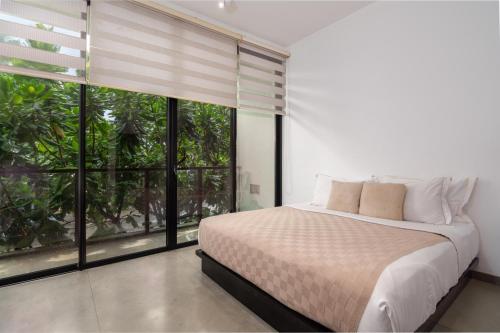 a bedroom with a bed and large windows at W15 Weligama in Weligama