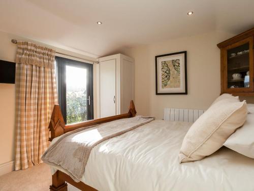 a bedroom with a large bed with a window at Holders Cottage in Lassington