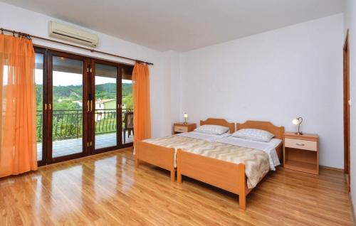 a bedroom with a bed and a balcony at Rooms Marija - rooms with pool in Trilj