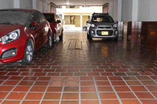 two cars parked in a parking lot in the rain at Hotel Brisas De Calima in Cali