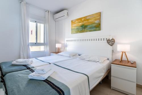 een witte slaapkamer met een groot bed en een raam bij On The Beach Sea View Patricia 132 in Marbella