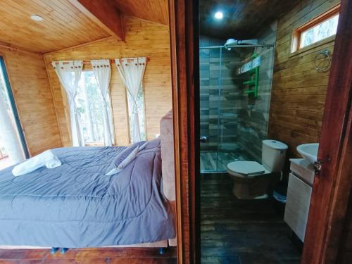 1 dormitorio con cama, ducha y baño en Casa en el Árbol Guatavita en Guatavita