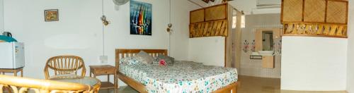 a bedroom with a bed and a table and a chair at La Villa Allamanda in Rodrigues Island