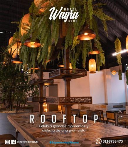 a restaurant with pendant lights and a wooden table at Hotel Wayra Club in Acacías