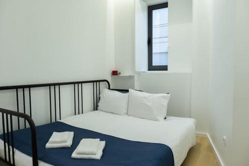 a bedroom with a bed with two towels on it at Porto Santa Maria Apartments in Porto