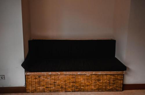 a wicker bed in a corner of a room at Tirta Sari in Tampaksiring