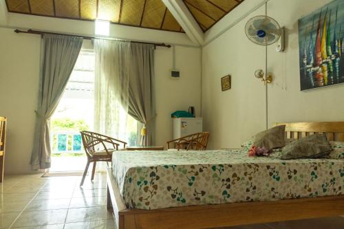 a bedroom with a bed and a large window at La Villa Allamanda in Rodrigues Island