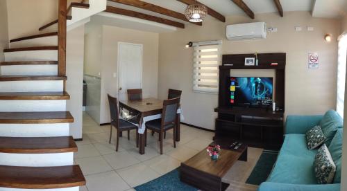 ein Wohnzimmer mit einem Sofa, einem Tisch und einem TV in der Unterkunft ENTRE CISNES 1, 2 y 3 Dorm in Valdivia