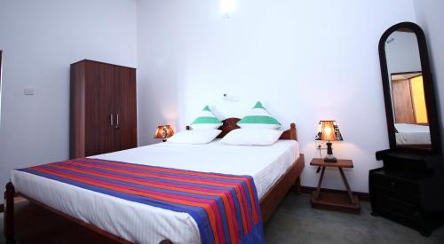 a bedroom with a large bed with a mirror at Ocean Breeze Villa in Galle