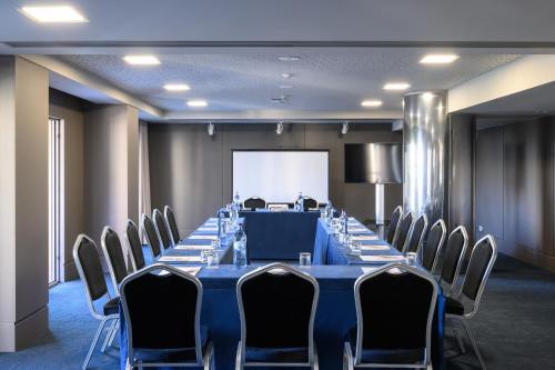 a conference room with a long table and chairs at Melia Setubal in Setúbal