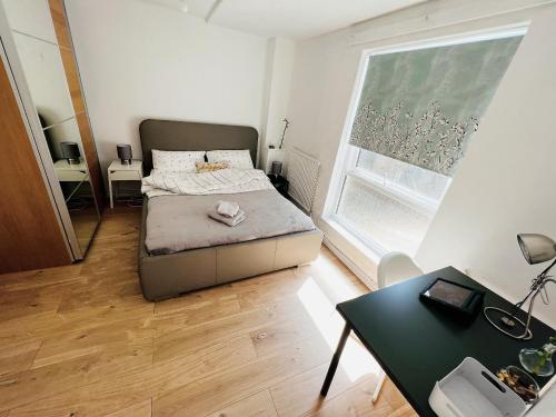 a small bedroom with a bed and a table at Extra Large Double one Bedroom Rental Near Central London & Close to Transport in London