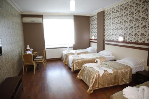 a hotel room with four beds and a window at Safir Hotels Silivri in Silivri