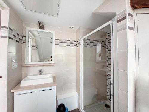 a white bathroom with a sink and a shower at Au Fil De L'eau - Les Remparts in Dinan