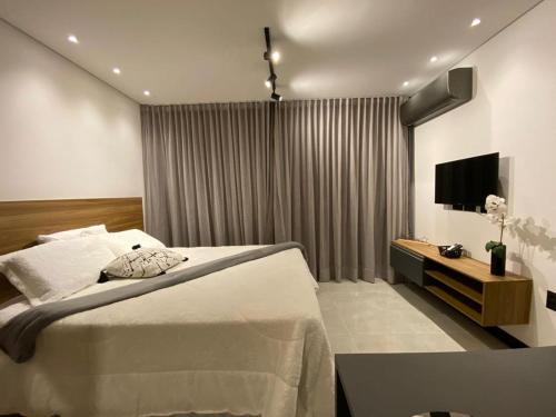 um quarto com uma cama grande e uma televisão em Sky Concept 816 em Maceió