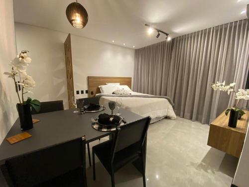 um quarto de hotel com uma cama, uma mesa e cadeiras em Sky Concept 816 em Maceió