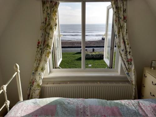 um quarto com uma janela com vista para o oceano em NewParade em Worthing