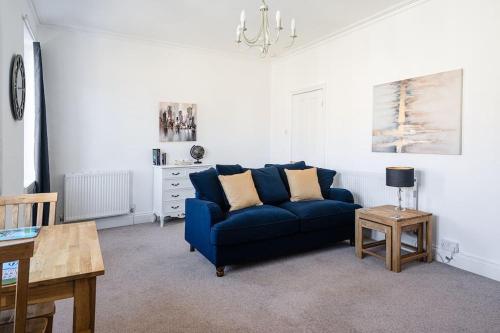 a living room with a blue couch and a table at Central Bath apartment in Bath