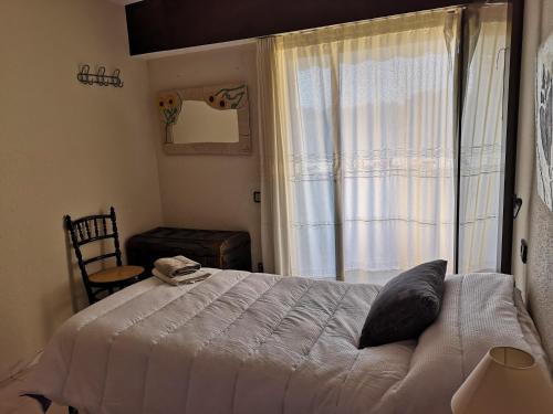 a bedroom with a bed and a large window at Apartamento Les Fonts in Polop