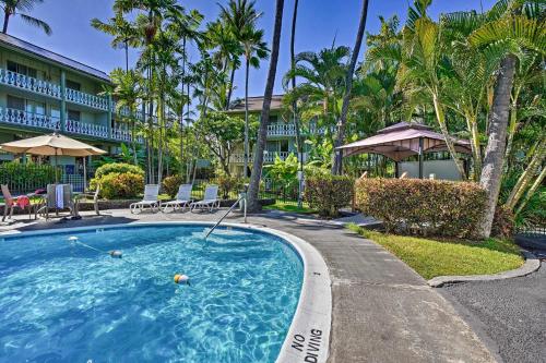 a swimming pool at a resort with palm trees at Downtown Kailua-Kona Escape Steps to Ocean! in Kailua-Kona