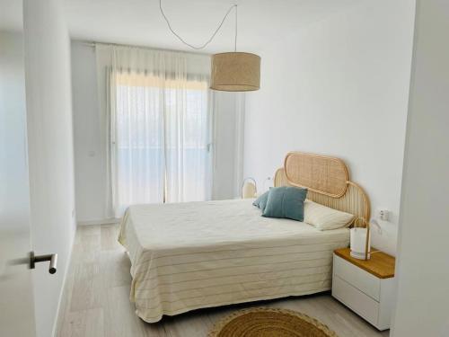 una camera da letto con un grande letto in una stanza bianca di Apartment- Roques Daurades Residential a L'Ametlla de Mar