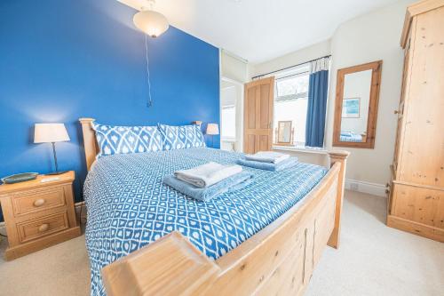 a blue bedroom with a large bed with blue sheets at The Gallery Coniston in Coniston