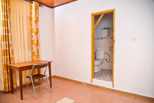 uma pequena casa de banho com uma mesa e um WC em Appartement meublé 2 chambres avec salle de bain - 1 salon - 1e cuisine - La Concorde - Quartier Nkomkana em Yaoundé