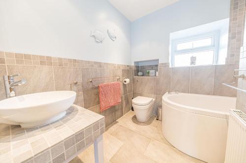ein Badezimmer mit einer Badewanne, einem Waschbecken und einem WC in der Unterkunft The Gallery Coniston in Coniston