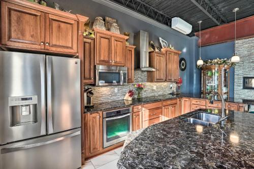a kitchen with wooden cabinets and a stainless steel refrigerator at Regal River Retreat in the Heart of Yankton! in Yankton