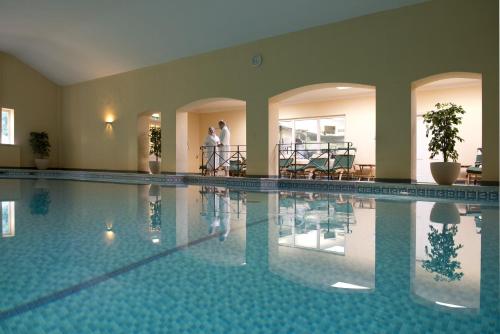 a large swimming pool with two people standing in the background at Bodysgallen Hall and Spa in Llandudno