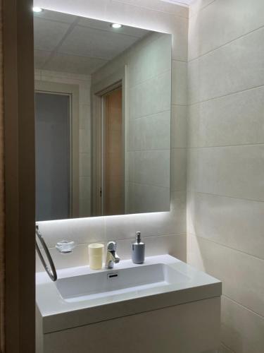 een badkamer met een witte wastafel en een spiegel bij Luxury apartment in Flamenca Village/Orihuela Costa in Orihuela-Costa