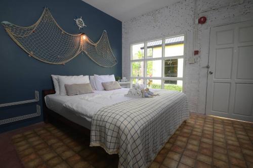 um quarto com uma cama com um urso de peluche em Hugs Home & Cafe Trang em Trang