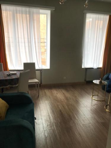 ein Wohnzimmer mit einem Sofa und 2 Fenstern in der Unterkunft My second home in Tbilisi City