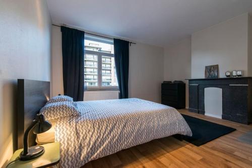 een slaapkamer met een bed en een raam bij Appartement 4 chambres à Liège in Luik