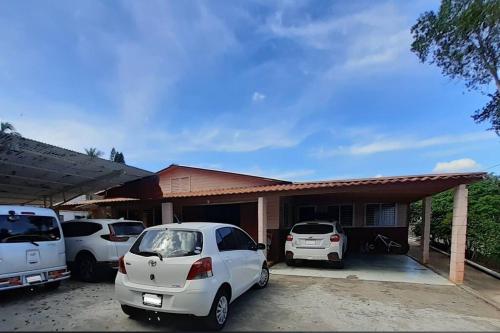 two cars parked in front of a house at Habitación Hogareña in Jarabacoa