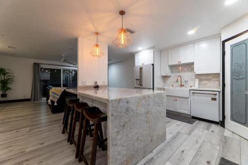 a large kitchen with a marble counter and chairs at Modern San Pedro Home, Sleeps 12, Hot Tub, Fire Place, Private Parking in San Pedro
