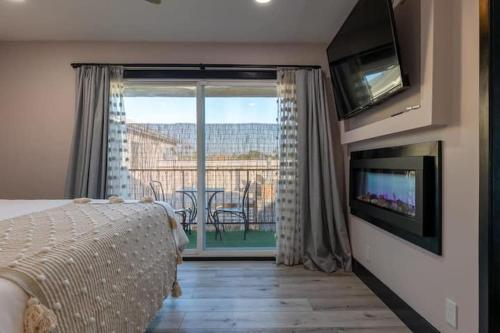 a bedroom with a bed and a television and a balcony at Modern San Pedro Home Sleeps 12 in San Pedro
