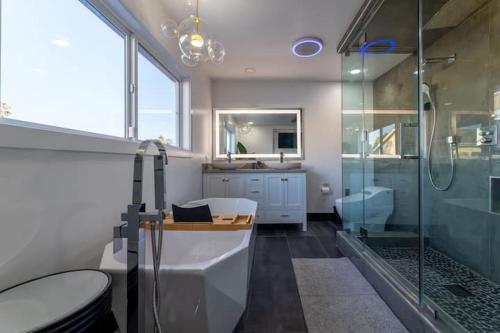 a bathroom with a tub and a shower and a sink at Modern San Pedro Home in San Pedro
