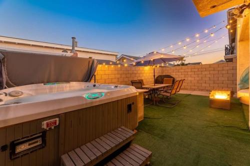 a hot tub on a patio with a table and chairs at Modern San Pedro Home, Sleeps 12, Hot Tub, Fire Place, Private Parking in San Pedro