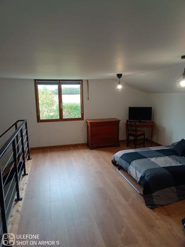 une chambre avec un lit, un bureau et une fenêtre dans l'établissement Charmante maison a la ferme, à Bonnes