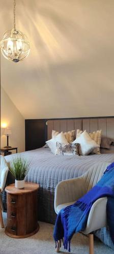 a bedroom with a bed with a blue blanket on it at Cosy Country Retreat in the Brecon Beacons in Crickhowell