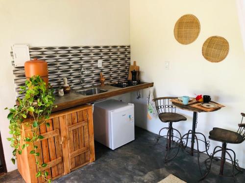 una cucina con lavandino e bancone con tavolo di Aruanã - Praia do Sargi a Serra Grande