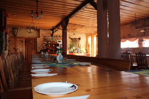 a long dining room with a long table with plates on it at Agroturystyka Kociewiak in Szteklin