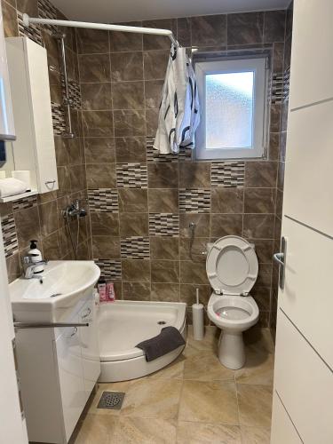 a bathroom with a sink and a toilet and a window at Apartmani "Stari Grad - Samobor" in Samobor