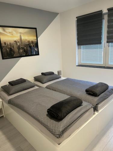 two beds in a white room with black pillows on them at Apartmani "Stari Grad - Samobor" in Samobor